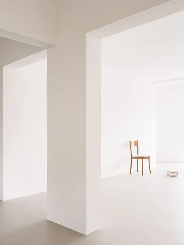 Minimalist interior with single chair and books, minimal, corporate-clean, light