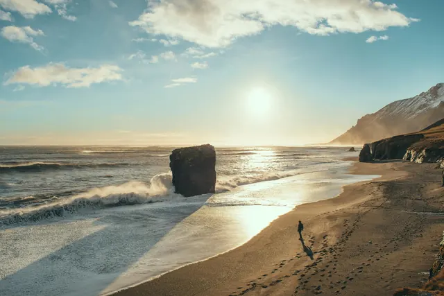 Icelandic beach landscape with solitary figure, photographic, minimalist, warm