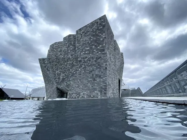 Modern stone building reflected in water, photographic, brutalist, cool