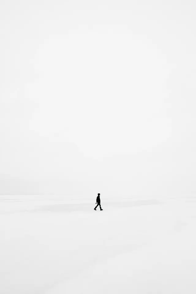 Solitary figure on minimal snowy landscape, minimal, photographic, monochrome