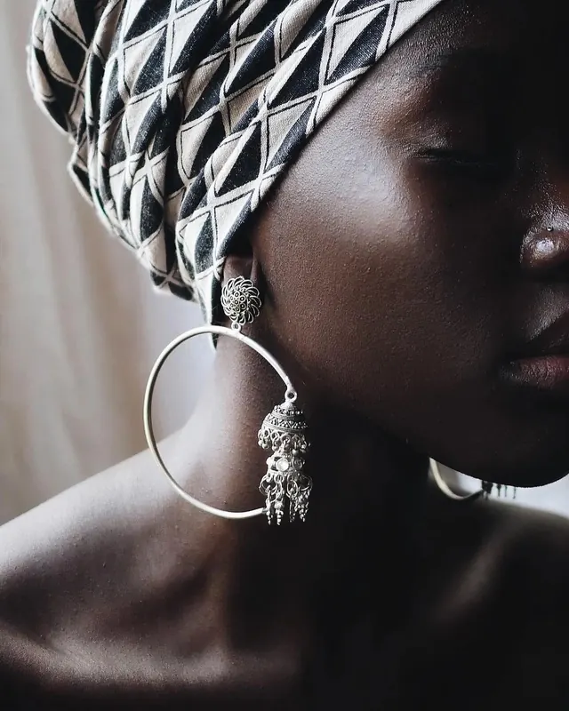 Portrait with ornate jewelry, photographic, minimalist, dark