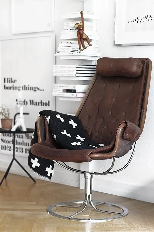 Styled home interior with brown chair and wall art, minimal, photographic, light