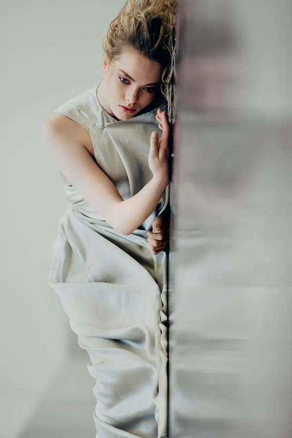 Woman leaning against reflective surface