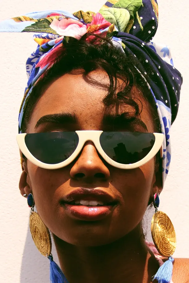 Woman with colorful headwrap and sunglasses, photographic, vibrant, warm