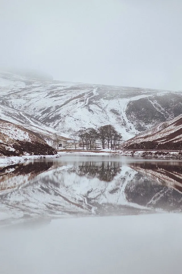 Misty snow-covered mountain lake, minimal, photographic, muted