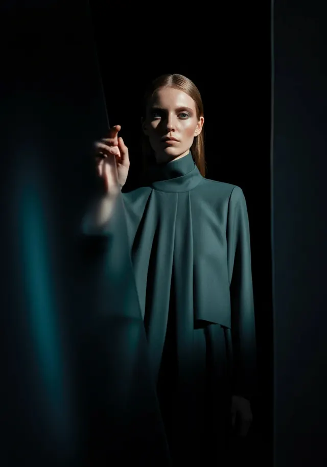 Studio fashion portrait in teal draped top, editorial, minimal, dark