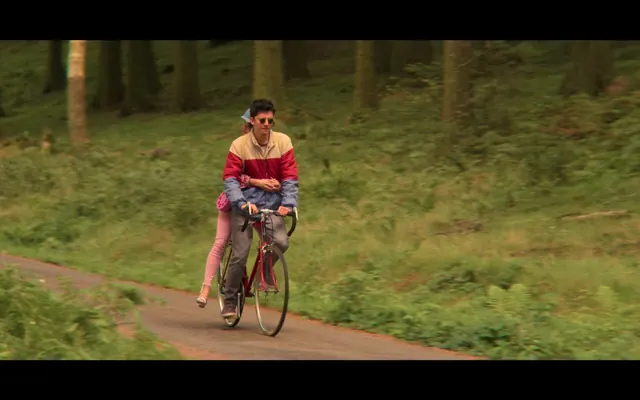 Woman Cycling on Forest Path