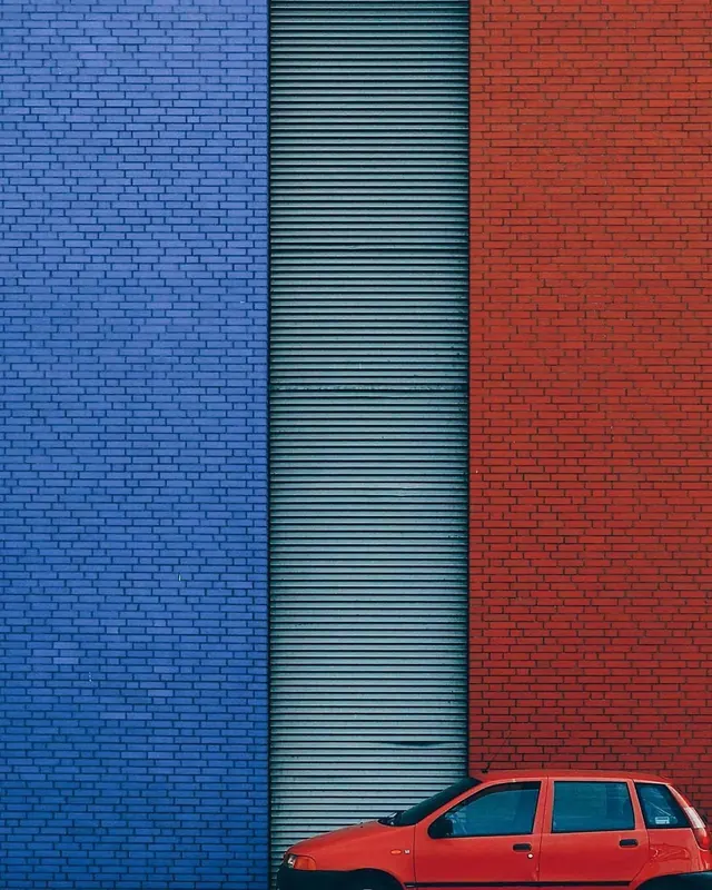 Red Car against Textured Wall