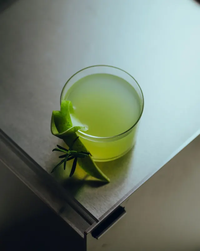 Green Juice Glass on Metallic Surface