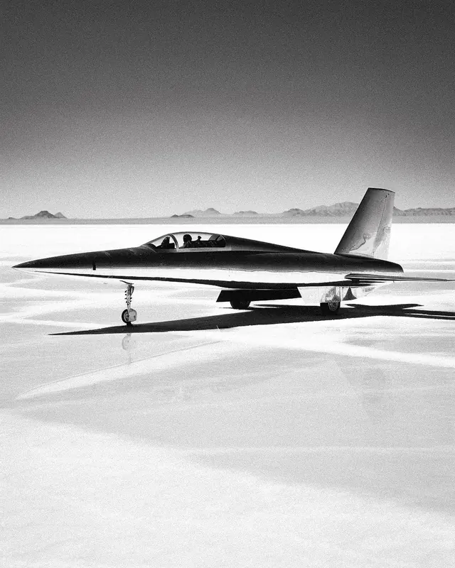 Fighter jet on salt flat, minimal, photographic, monochrome