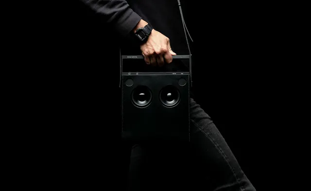 Hand holding black speaker