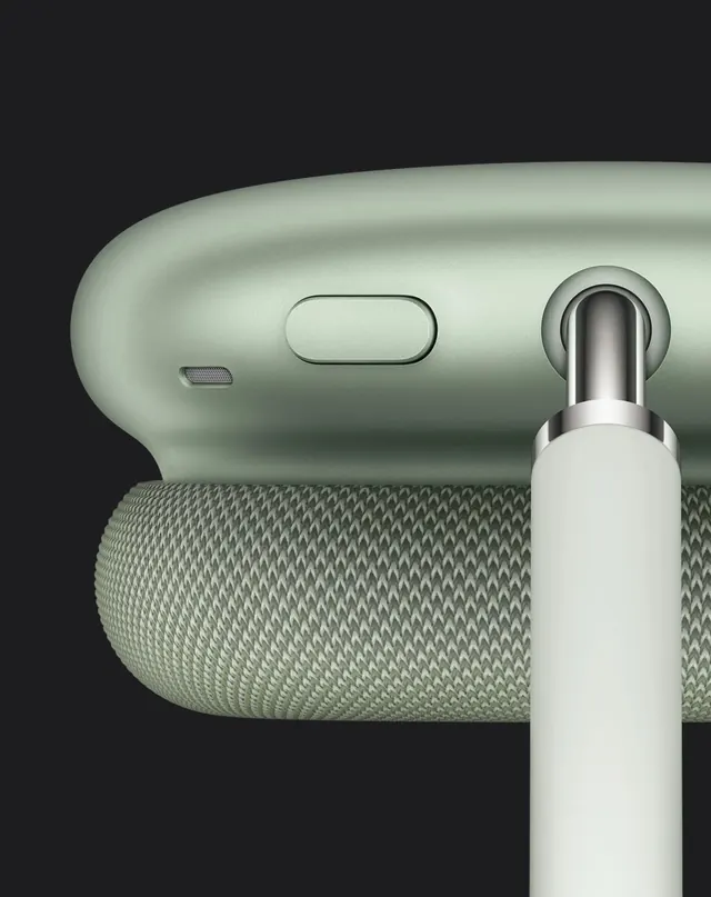 Close-up of sage green over-ear headphones with fabric earcup, minimal, muted