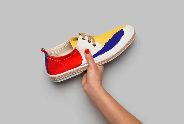 Hand Holding Colorful Sneaker