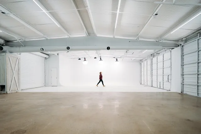 Minimal industrial photo studio with person in white cyclorama, minimal, photographic, light
