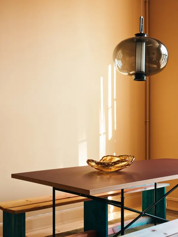 Interior styling with sculptural pendant and warm tones, photographic, minimal, warm