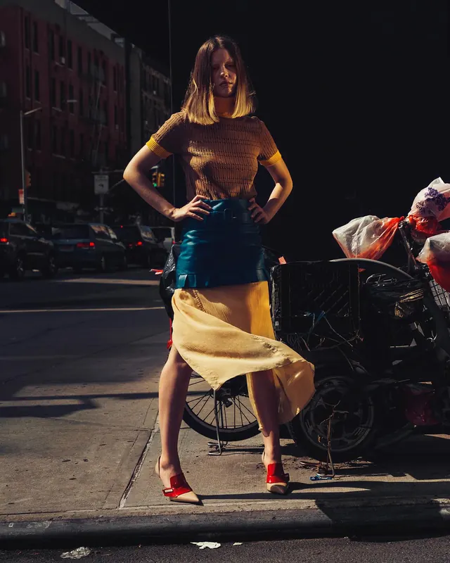 Street portrait with dramatic sidelight and flowing fabric, photographic, editorial, warm