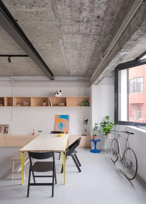 Industrial workspace with raw concrete and wood elements, minimal, brutalist, warm