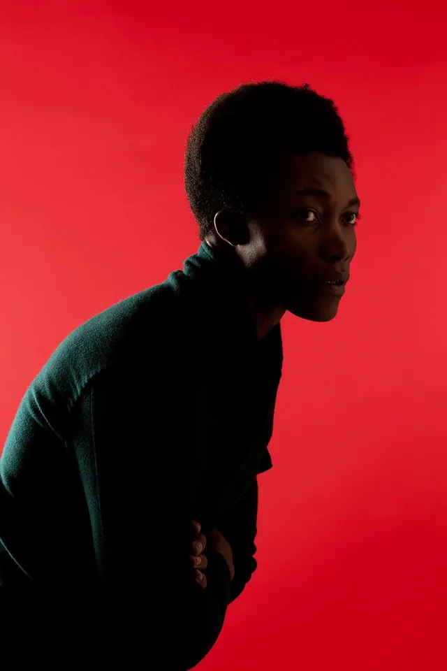 High contrast portrait against red background, photographic, high-contrast, vibrant