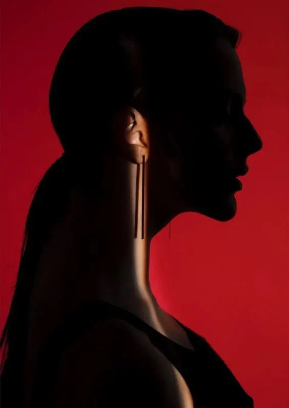 Deep red silhouette portrait with minimal lighting, photographic, minimalist, dark