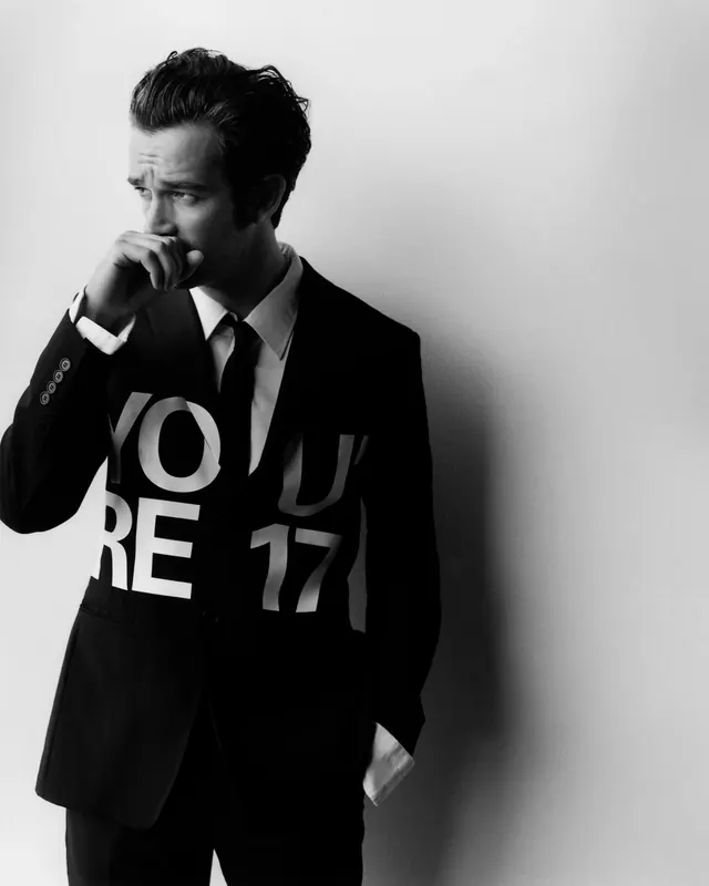 Portrait of person in black suit with abstract typography overlay, photographic, monochrome, monochrome