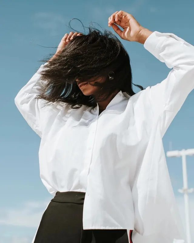 Woman in white shirt portrait against blue sky, photographic, minimal, light