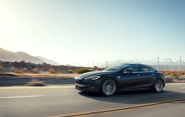 Tesla vehicle on highway with wind turbines and desert landscape, photographic, minimal, light