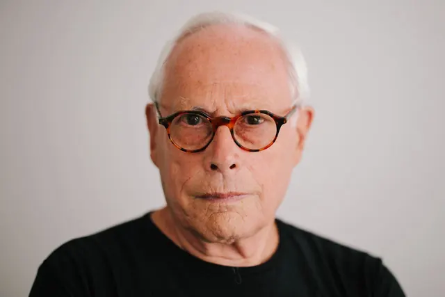 Portrait of person with glasses and neutral expression, photographic, corporate-clean, light