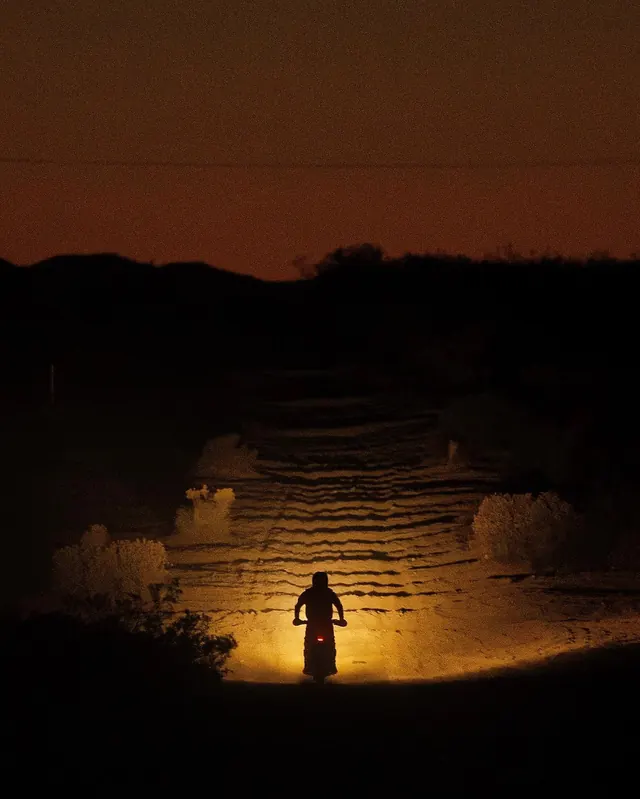 Desert rider at sunset in dramatic lighting, photographic, dark-mode, dark