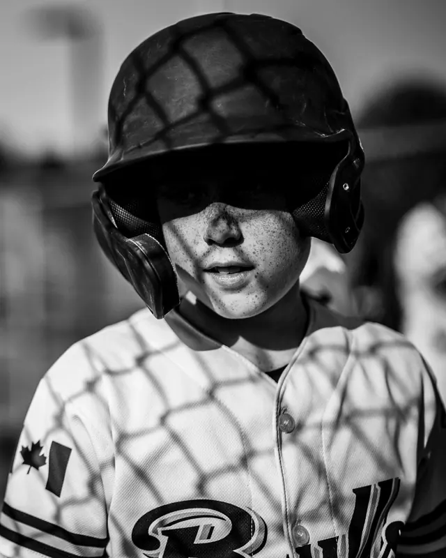 Baseball player portrait with headphones and helmet, photographic, editorial, monochrome