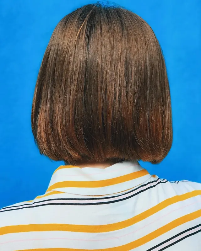 Rear view portrait with striped shirt and bright blue background, photographic, minimalist, vibrant