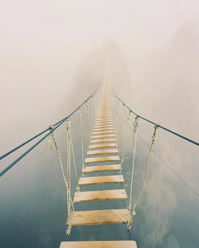 Suspension bridge disappearing into fog, photographic, geometric, muted