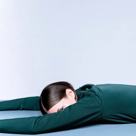 Minimalist teal figure study in prone pose, minimal, photographic, cool