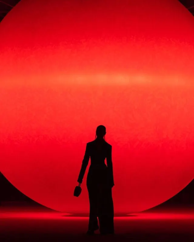 Silhouette before giant red sphere, editorial, photographic, dark