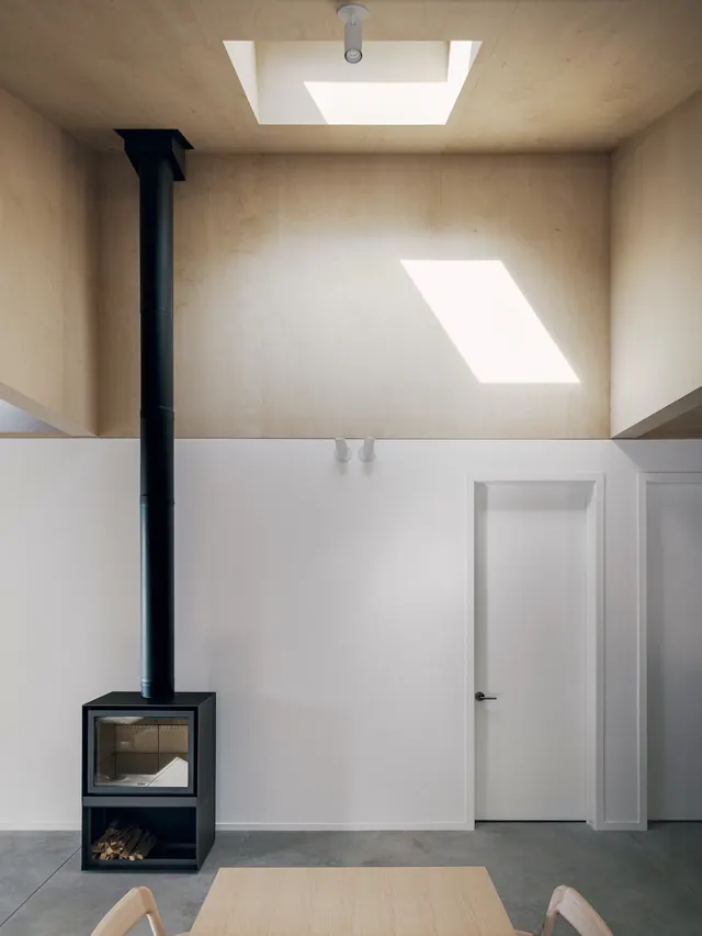Plywood loft with black wood stove, minimal, organic, light