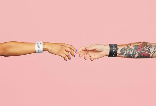 Reaching Hands with Wristband Messages, minimal, editorial, warm