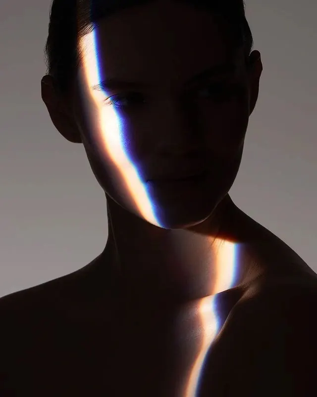Prismatic light stripe portrait, photographic, minimal, dark