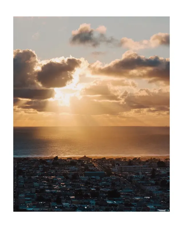 Coastal city sunset god rays, photographic, minimal, warm