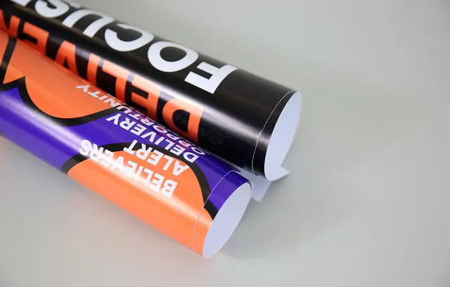Rolled vinyl signage with bold typography, minimal, photographic, high-contrast
