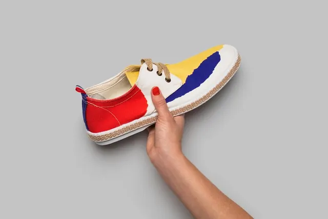 Hand Holding Colorful Sneaker