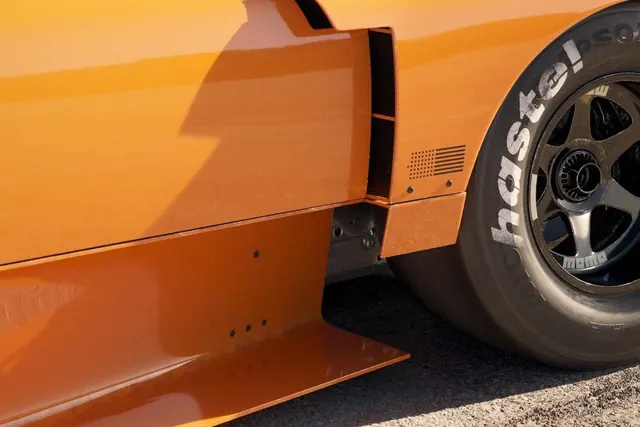 Orange race car wheel detail, photographic, technical, vibrant