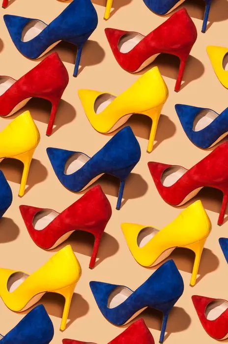 Primary-color heels flat lay, photographic, playful, vibrant