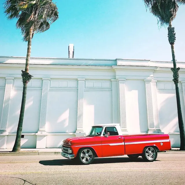 Red vintage truck and palm trees, photographic, retro, vibrant