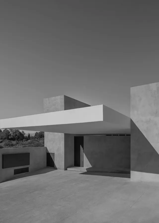 Cantilevered modern house in black and white, minimal, brutalist, monochrome