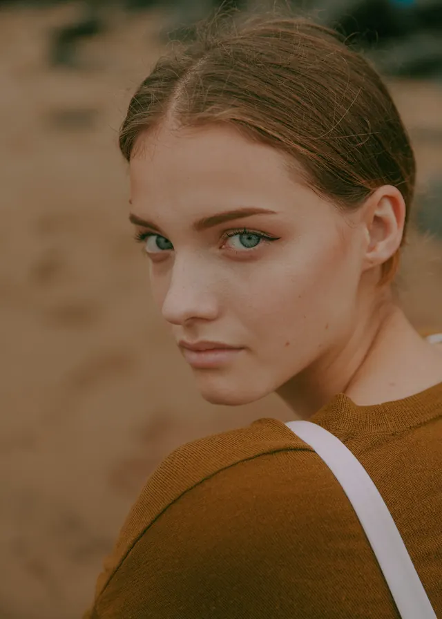 Over-shoulder portrait in ochre knit, photographic, minimal, warm