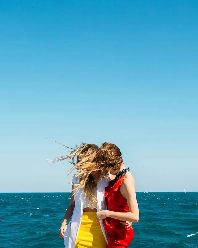 Two women on boat with wind-blown hair, photographic, editorial, vibrant