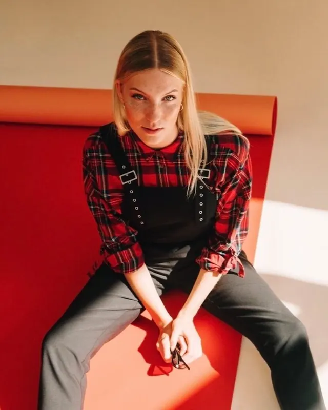Freckled model on red seamless with plaid shirt, photographic, editorial, vibrant