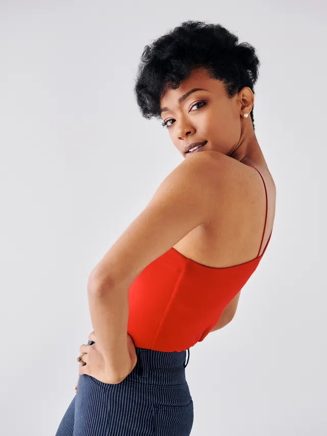 Portrait of woman in red top over shoulder, minimal, photographic, vibrant