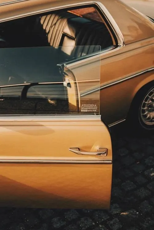 Vintage car door with chrome handle and overlay, photographic, minimal, warm