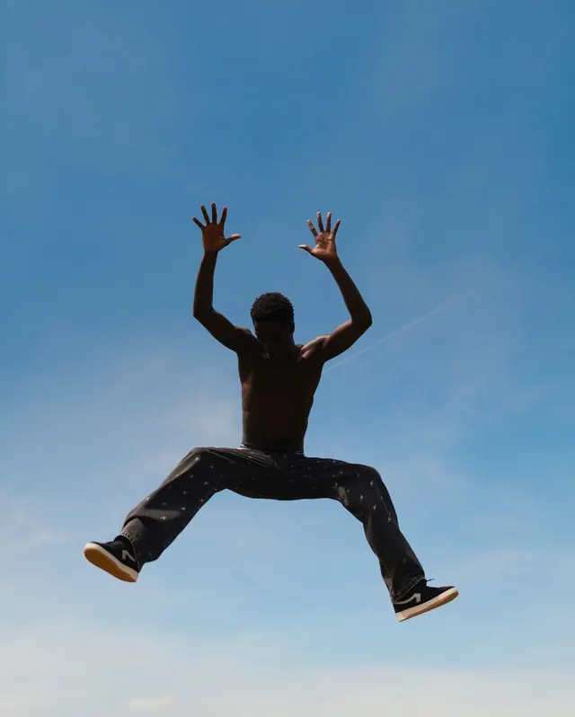 Person Jumping Against Blue Sky