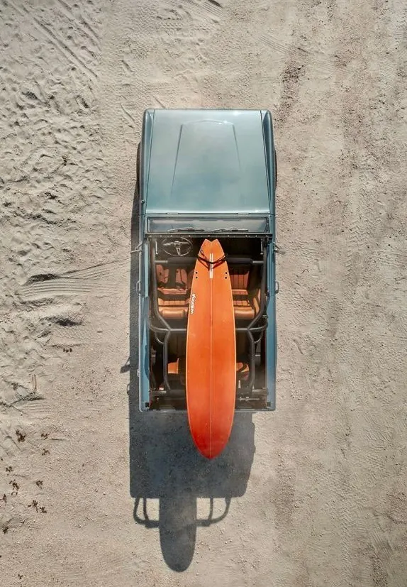 Orange Surfboard and Van in Sand